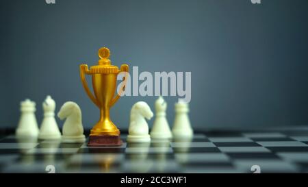 Geschäftsstrategie konzeptionelles Foto – Goldene Trophäe auf Schachbrett Mit Schachfigur Stockfoto