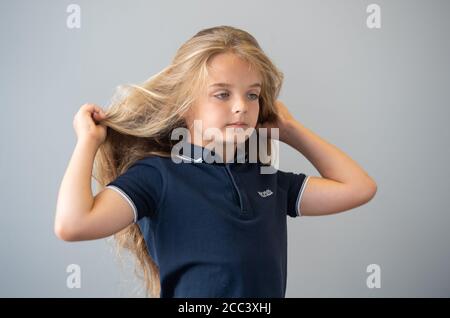 Reilly Stancombe, bevor er seinen ersten Haarschnitt bei Masters & Misters Barbers in Clacton-on-Sea, Essex, machte, um Geld für den Little Princess Trust zu sammeln. Der neunjährige Reilly aus Little Clacton, Essex, der noch nie einen Haarschnitt bekommen hat, spendet seine langen Haare, um sie zu Perücken für krebskranke Kinder zu machen. Stockfoto