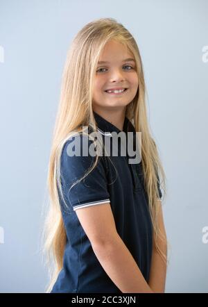 Reilly Stancombe, bevor er seinen ersten Haarschnitt bei Masters & Misters Barbers in Clacton-on-Sea, Essex, machte, um Geld für den Little Princess Trust zu sammeln. Der neunjährige Reilly aus Little Clacton, Essex, der noch nie einen Haarschnitt bekommen hat, spendet seine langen Haare, um sie zu Perücken für krebskranke Kinder zu machen. Stockfoto