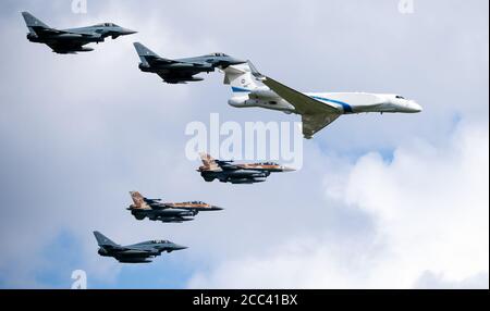 Fürstenfeldbruck, Deutschland. 18. August 2020, Bayern, Fürstenfeldbruck: Zwei Kampfflugzeuge des Typs F-16 (bräunliche Tarnung) der israelischen Luftwaffe (IAF), drei Eurofighter der Bundeswehr (grau) und ein Learjet der israelischen Luftwaffe fliegen in Formation über den Luftwaffenstützpunkt Fürstenfeldbruck zum Gedenken an das Attentat bei den Olympischen Spielen 1972. Für die Luftkampfübungen Blue Wings 2020 und MAGDAYs und eine gemeinsame Gedenkfeier landeten erstmals Kampfflugzeuge der israelischen Luftwaffe in Deutschland. Quelle: dpa picture Alliance/Alamy Live News Stockfoto