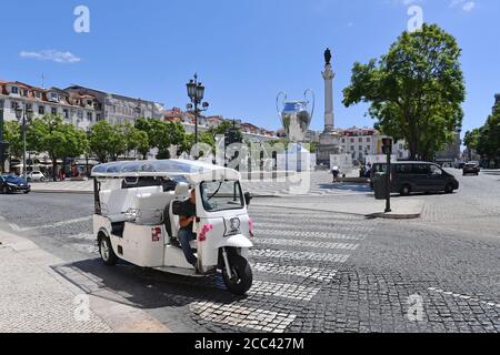 Lissabon, Portugal. August 2020. Nachbau des Champions-League-Pokals, Pokals, Pokals anlässlich des Champions-League-Finalturniers auf dem Rossio - im Vordergrund ein leeres elektrisches TukTuk. Der Rossio, offiziell Praca de D. Pedro IV, ist einer der berühmtesten Orte, Eindrücke aus Lissabon in Zeiten der Coronavirus-Pandemie am 16. August 2020. Quelle: dpa/Alamy Live News Stockfoto