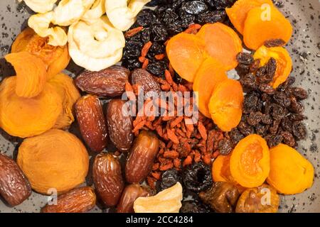 Sammlung von verschiedenen getrockneten Früchten auf einem Tisch isoliert auf einem grauen Hintergrund. Flache Ansicht. Stockfoto