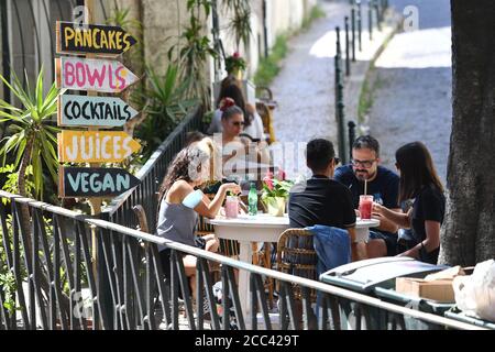 Lissabon, Portugal. August 2020. Die Gäste der Bar sitzen an Tischen im Freien. Gastronomie. In Portugal leidet die Tourismusbranche massiv unter den Folgen der Coronavirus-Pandemie - trotz Hochsaison und Urlaubszeit sind die Straßen der Altstadt fast menschenleer, leer. Eindrücke aus Lissabon während der Coronavirus-Pandemie am 16. August 2020. Quelle: dpa/Alamy Live News Stockfoto