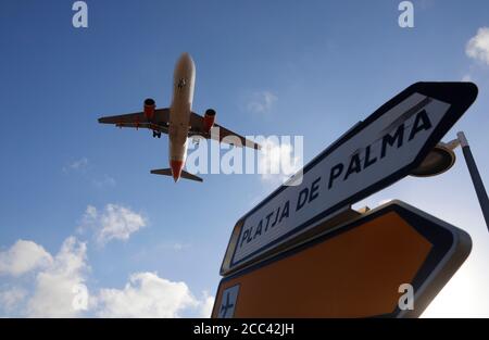 18. August 2020, Spanien, Palma: Bei der Landung auf Mallorca fliegt ein Flugzeug über ein Schild in Richtung Playa de Palma. Das Auswärtige Amt hatte am Freitag für fast ganz Spanien eine Reisewarnung herausgegeben. Es gilt auch für die Balearen einschließlich der wichtigsten Destination Mallorca. Foto: Clara Margais/dpa Stockfoto