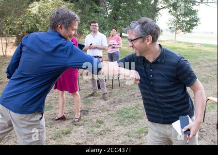 Zeithain, Deutschland. August 2020. Robert Habeck (l.), Bundesvorsitzender von Bündnis 90/die Grünen, begrüßt einen Journalisten auf seiner Sommertournee. Auf seiner Reise will Habeck herausfinden, wie das Land als Lehre aus der Corona-Krise widerstandsfähiger und krisensicherer werden kann. Quelle: Sebastian Kahnert/dpa-Zentralbild/dpa/Alamy Live News Stockfoto