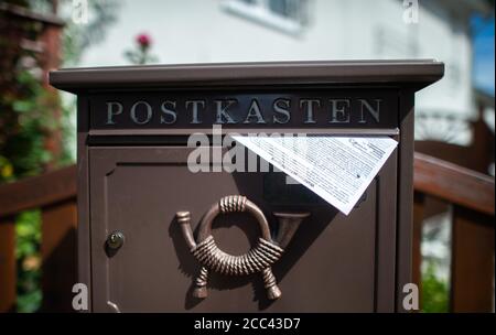 18. August 2020, Nordrhein-Westfalen, Gevelsberg: Eine Wahlbenachrichtigung wird in einem Briefkasten abgelegt. Ab heute werden in Nordrhein-Westfalen die Wahlbenachrichtigungen für die Kommunalwahlen, die Landtagswahlen, die Bürgermeisterwahlen und die Verbandswahlen am 13. September zugestellt. Foto: Jonas Güttler/dpa Stockfoto