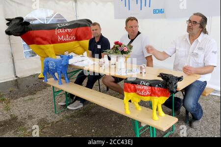 18. August 2020, Mecklenburg-Vorpommern, Papendorf: Zwischen Plastikkühen mit der Aufschrift "die faire Milch" Klaus-Dieter Augustin (l-r), Mitglied des Landesvorstandes des Bundesverbandes Deutscher Milchviehhalter (BDM), Harry Weijs, Leiter des Landgutes Papendorf, Und Gerd Schütte, Mitglied des Landesvorstandes des BDM, informiert auf einer Pressekonferenz des Mecklenburg-Vorpommern-Landesteams des BDM über die angespannte Lage der Milchbauern im Norden. Foto: Bernd Wüstneck/dpa-Zentralbild/ZB Stockfoto