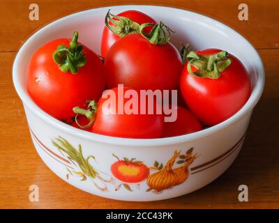 Frisch gepflückte hellrote selbstgewachsene Tomaten, Sorte Mountain Magic, in einer kleinen Schüssel Stockfoto