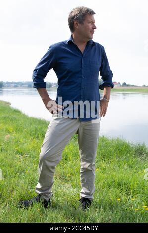 Zeithain, Deutschland. August 2020. Robert Habeck, Bundesvorsitzender von Bündnis 90/die Grünen, steht während einer Sommertour am Ufer der Elbe. Habeck will auf seiner Reise herausfinden, wie das Land widerstandsfähiger und krisensicherer werden kann, als Lehre aus der Corona-Krise. Quelle: Sebastian Kahnert/dpa-Zentralbild/dpa/Alamy Live News Stockfoto