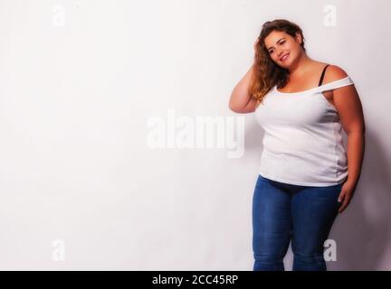 Schönes blondes Plus Size Modell in ärmellosen Hemd und Jeans Stockfoto