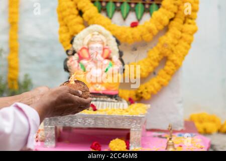 Nahaufnahme der Hände anbeten lord ganesh, indem aarti während vinayaka Chaturthi Festival pooja oder puja Feier zu Hause in Indien anbietet. Stockfoto