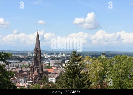 Freiburger Münster, der Dom zu Freiburg im Breisgau, Südwestdeutschland. Der im Mittelalter fertiggestellte gotische Kirchturm ist von einem Gebäude umgeben. Stockfoto