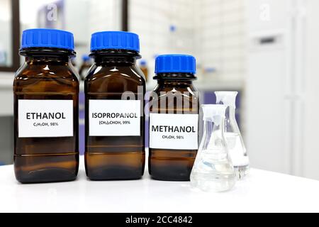 Selektiver Fokus von Ethanol, Methanol und Isopropanol braunen Braunglasflaschen in einem Labor. Verschiedene Arten von Alkohol. Stockfoto