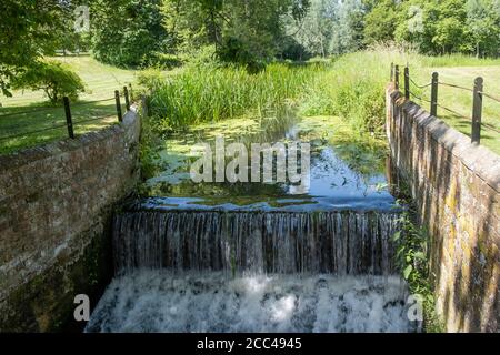 Kleiner Kanal Wehr auf Langleys Anwesen in Great Waltham, Essex, England Stockfoto