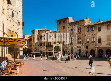 Schöne Aussicht auf die beliebte Piazza della Cisterna, der Hauptplatz von San Gimignano, Toskana, Italien. Umgeben von mittelalterlichen Häusern, ist die Zisterne... Stockfoto