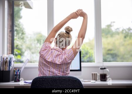 Rückansicht Einer Frau, Die Von Zu Hause Aus Am Computer Arbeitet Heimbüro Stretching Am Schreibtisch Stockfoto