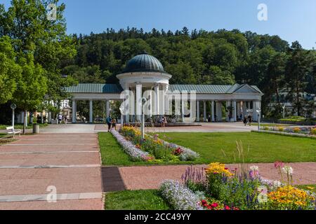 Marianske Lazne / Tschechien - August 11 2020: Blick auf die Kolonnade Rudolph und Caroline mit grünem Rasen und bunten Blumen. Stockfoto