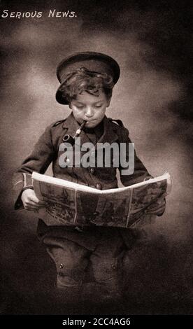 Humor Britische Propagandapostkarte aus der Zeit des Ersten Weltkriegs. Kleiner Junge in Uniform der britischen Armee mit rauchenden Pfeifenlesezeitung. Stockfoto