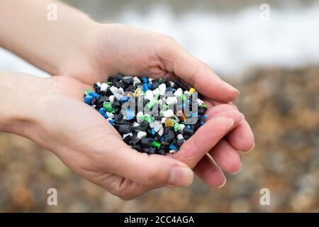 Nahaufnahme Von Hand Holding Plastic Granulate Polluting Beach Stockfoto