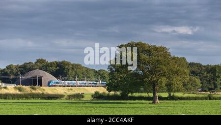 Erster TransPennine Express CAF Klasse 397 Elektrozug vorbei an der Landschaft an der Westküste Hauptlinie in Lancashire Stockfoto