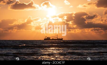 Trawler an der Nordseeküste bei schönem goldenen Sonnenuntergang Stockfoto