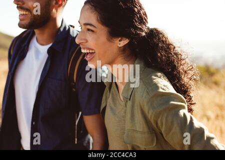 Glückliches Paar genießen auf einem Urlaub im Freien stehen. Ausgeschnittene Aufnahme einer lachenden Frau, die zusammen mit ihrem Freund steht. Stockfoto