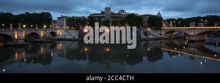 Ein Panoramablick auf den Tiber zwischen der Brücke Ponte Sant'Angelo und der Brücke Ponte Vittorio Emanuele II bei Nacht, Rom, Italien. Stockfoto