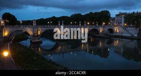 Blick auf den Tiber und die Brücke Ponte Sant'Angelo bei Nacht, Rom, Italien. Nachtlichter der Brücke Ponte Sant'Angelo Stockfoto