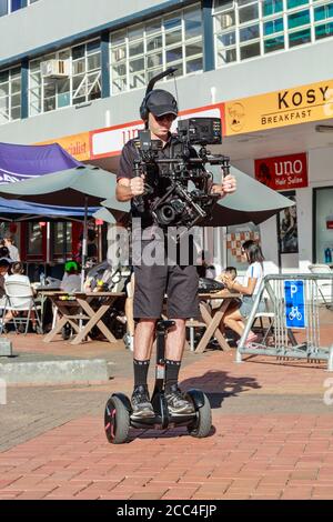 Ein Mann, der ein Video von einem Segway mit einem Stabilisator an seiner Kamera schießt. Hamilton, Neuseeland, 16/2019 Stockfoto