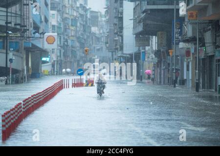 (200819) -- MACAO, 19. August 2020 (Xinhua) -- EIN Mann fährt im Regen auf einer Straße in Macao, Südchina, 19. August 2020. Chinas Sonderverwaltungsregion Macao hat sein Taifunssignal von der höchsten Stufe Nr. 10 auf Nr. 8 am Mittwoch um 7:30 Uhr Ortszeit heruntergestuft, aber die tief liegenden Gebiete in der Nähe der Küste wurden überflutet, da der Taifun Higos am Morgen in der Nachbarstadt Zhuhai landete. Quelle: Xinhua/Alamy Live News Stockfoto