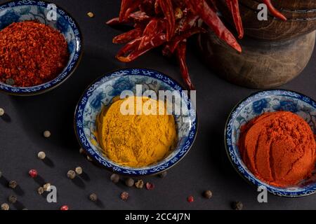 Traditionelle getrocknete Kräuter und Gewürze. Holzpresse und Stößel. Stillleben auf dunklem Hintergrund. Stockfoto