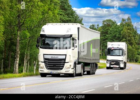 Zwei weiße Sattelschlepper, DAF XF vorne, liefern im Sommer Güter entlang der Autobahn. Raasepori, Finnland. Juli 24, 2020. Stockfoto