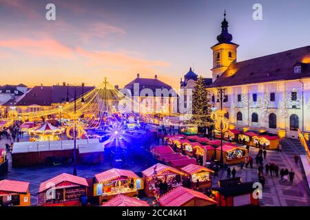 Sibiu, Rumänien. Weihnachtsmarkt in Piata Mare in der Dämmerung. Siebenbürgen, Rumänien. Stockfoto