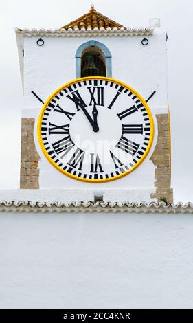 Kirche Uhr einer weißen mediterranen Kirche mit römischen Ziffern. Hände zeigen fünf Minuten bis zwölf. Zeitdruck, Termin, Dringlichkeit, Termin Stockfoto