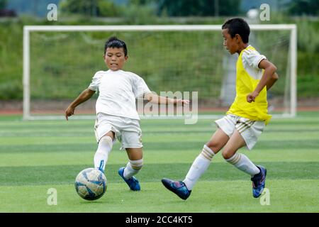 (200818) -- ZHAOJUE, 18. August 2020 (Xinhua) -- das Foto vom 12. August 2020 zeigt Jiniu Muniu (L) von Zhaojue Real Madrid, das auf dem Lamo-Fußballplatz im Bezirk Zhaojue, südwestlich der chinesischen Provinz Sichuan, Fußball spielt.Javier Moros Barrera, ein 30-jähriger UEFA A A A LEVEL Trainer aus Zaragoza, Spanien, Trainiert seit dem 13. Juli 2020 eine Fußballmannschaft aus 15 Jungen aus dem Bezirk Zhaojue und ländlichen Dörfern in der Nähe des Bezirks in der chinesischen Provinz Sichuan. Das Fußballteam namens Zhaojue Real Madrid Team ist Teil eines Trainingsprojekts, das im vergangenen Oktober gestartet wurde und von Real Madrid F unterstützt wurde Stockfoto