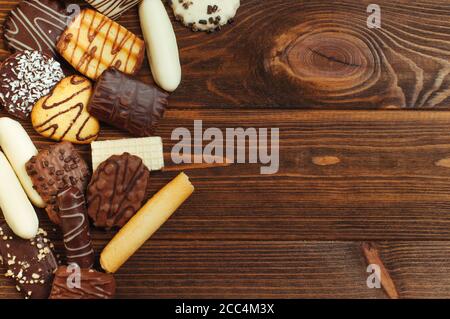 Auswahl an Keksen mit Schokolade auf Holzhintergrund bedeckt Stockfoto