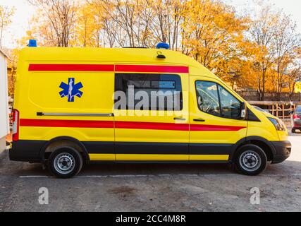 Zaporozhye/Ukraine- November 08 2019 : Gelber Krankenwagen steht in der Nähe des Krankenhausgebäudes.Seitenansicht eines Autos. Moderner Krankenwagen. Stockfoto