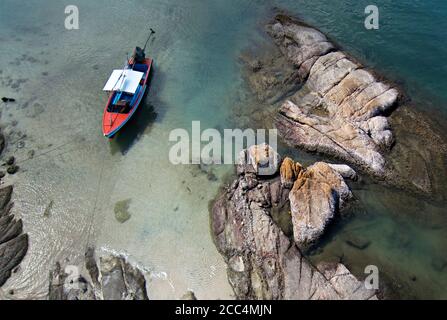 Blick auf das Longtail-Boot von oben neben den Felsen Stockfoto