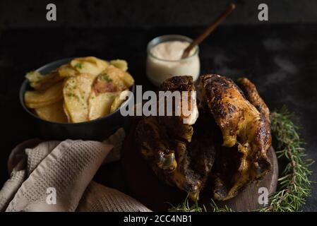 Nahaufnahme eines spanischen Gerichts, das aus Kartoffelchips besteht Und gebratenes Huhn mit Aioli Stockfoto