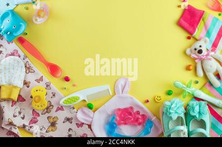 Baby Dusche Party Hintergrund mit Kleidung, Schuhe, Accessoires und Süßigkeiten auf dem gelben Hintergrund Stockfoto