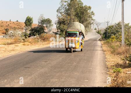 Puttaparthi, Andhra Pradesh, Indien - 12. Januar 2013: Indische Menschen reisen in Rikscha-Taxi entlang der Straße von Puttaparthi Dorf, Indien Stockfoto