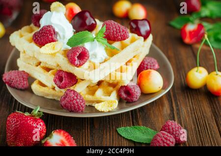 Belgische Waffeln mit Beeren, Schlagsahne und geriebener Schokolade Stockfoto