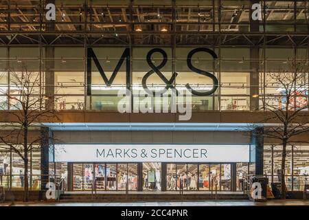 Manchester, UK Marks & Spencer Ladenfassade mit Logo. Beleuchtete Nachtansicht des britischen Einzelhändlers M&S Group plc geschlossener Ladeneingang mit Logo & Schild. Stockfoto