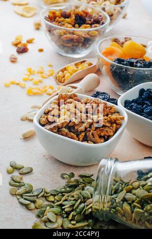 Nahaufnahme von getrockneten Früchten, Nüssen und Samen in Glasschüsseln Stockfoto