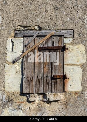 Alte verwitterte Holztür geschlossen mit zusätzlichen genagelten Lattens. Stockfoto