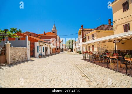 Gepflasterter Platz und alte Straße mit Steinbrunnen in der Historische Stadt Nin in Dalmatien Stockfoto