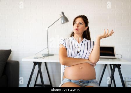 Schwangere Frau von zu Hause aus arbeiten. Karriere und Schwangerschaft Konzept Stockfoto