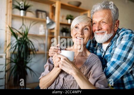 Glücklich lächelnde senior Paar zusammen zu Hause umarmen Stockfoto