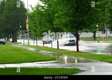 Bürger des Fond du Lac fahren in ihren Fahrzeugen durch die überfluteten Straßen vor dem riesigen Regenschauer am Nachmittag des juli 2020. Stockfoto