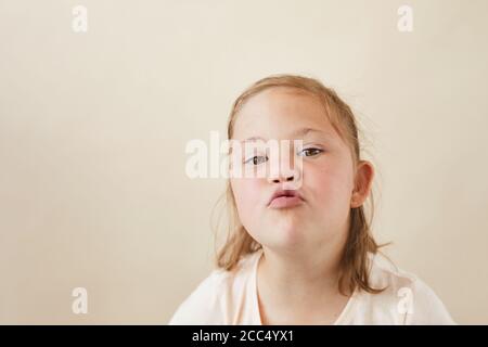 Portrait von kleinen Mädchen mit Down-Syndrom Senden des Kuss Auf weißem Hintergrund isolierte Kamera Stockfoto